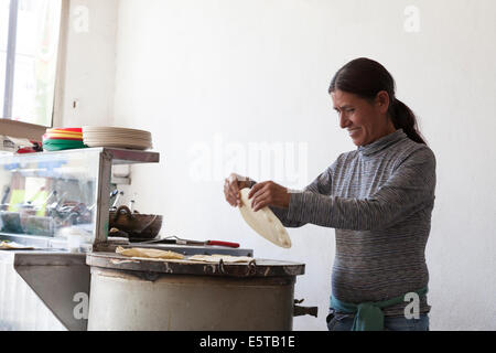 Woman making tortillas on a comal at Mi Taquito taquería in the Centro Historico Stock Photo