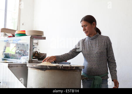 Woman making tortillas on a comal at Mi Taquito taquería in the Centro Historico Stock Photo