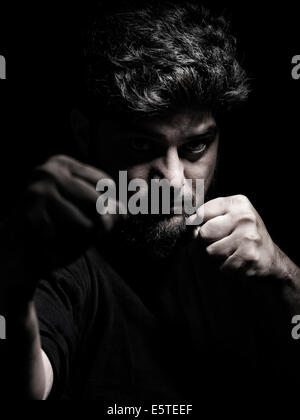 License available at MaximImages.com - Dramatic portrait of a man in a fighting stance with fists in front of his face Stock Photo