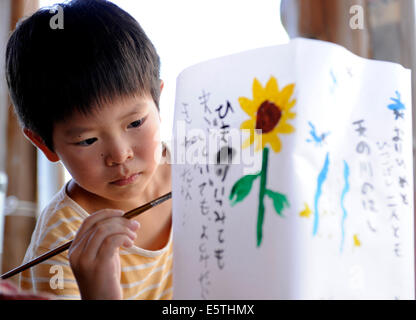 Tokyo, Japan. 6th Aug, 2014. A Japanese boy paints on a lantern to mark the 69th anniversary of the US atomic bombing of Hiroshima at Maruki Gallary in Saitama, Japan, Aug. 6, 2014. Credit:  Stringer/Xinhua/Alamy Live News Stock Photo