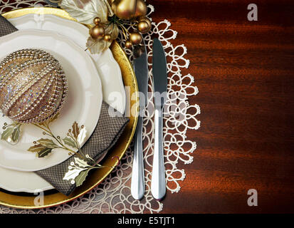 Latest trend of gold metallic theme Christmas  formal dinner table place setting with fine bone china, bauble Stock Photo