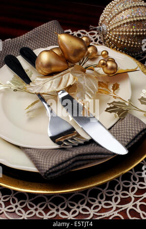 Latest trend of gold metallic theme Christmas  formal dinner table place setting with fine bone china, bauble Stock Photo