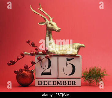 Save the date white block calendar with gold glitter reindeer and decorations against a red background for Christmas Day Stock Photo