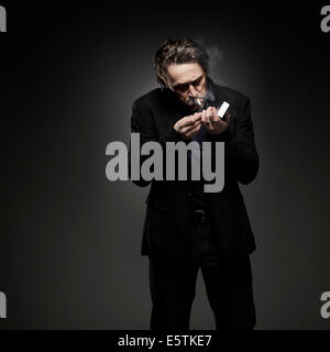 Robert Crampton who is a cigarette smoker studio shot wear black suit Stock Photo