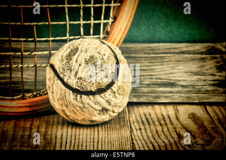 old tennis ball and racket on a wooden floor Stock Photo