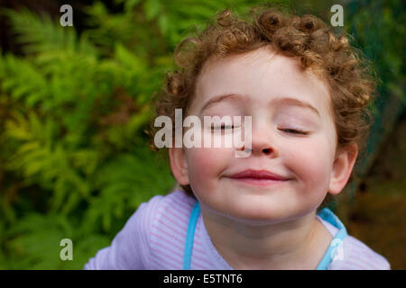 Young curly haired girl pulling a funny face Stock Photo