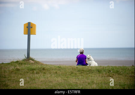Port beach, County Louth, Ireland. 6th August, 2014. Karen Winters from Clogherhead, County Louth with her dog 'Lucky', a Japanese Spitz on Port beach, County Louth. Credit:  Barry Cronin/Alamy Live News Stock Photo