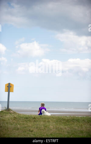 Port beach, County Louth, Ireland. 6th August, 2014. Karen Winters from Clogherhead, County Louth with her dog 'Lucky', a Japanese Spitz on Port beach, County Louth. Credit:  Barry Cronin/Alamy Live News Stock Photo