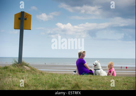 Port beach, County Louth, Ireland. 6th August, 2014. Karen Winters from Clogherhead, County Louth with her daughter Lucille and dog 'Lucky', a Japanese Spitz on Port beach, County Louth Credit:  Barry Cronin/Alamy Live News Stock Photo