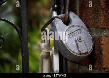 Padlock and chain securing a wrought iron gate Stock Photo