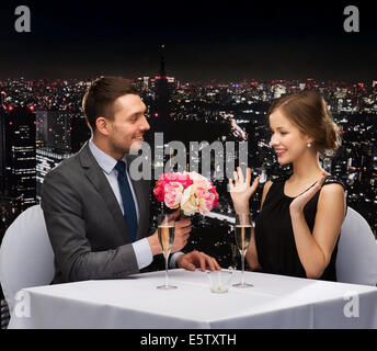 smiling man giving flower bouquet to woman Stock Photo