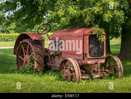 An old McCormick-Deering tractor sits peacefully under an oak tree. Stock Photo