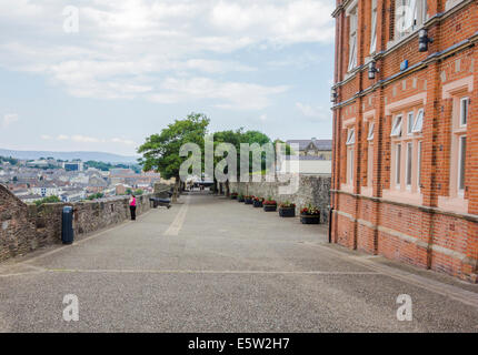 Lone woman looking over Derry's Walls Stock Photo