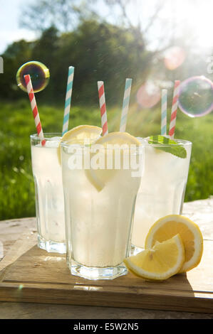 Homemade lemonade in tall glasses with straws on a summers evening in England. Stock Photo