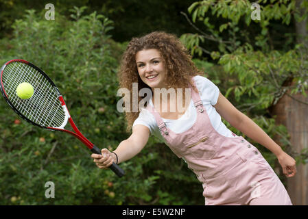 Attractive teenage girl playing tennis Stock Photo
