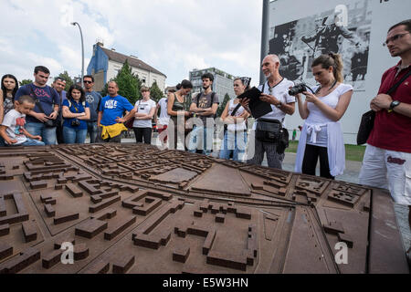 Tour group studies route of Berlin Wall from model at memorial park on Bernauer Strasse in Berlin Germany