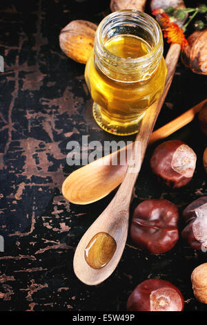A honey jar with a spoon for honey and different nuts on white b Stock  Photo by Nataljusja