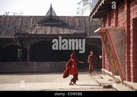 Young monks kicking a ball in a yard outside a monastery in Nyuangshwe, Myanmar (Burma). Stock Photo