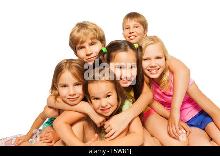 Six children sit hugging together Stock Photo