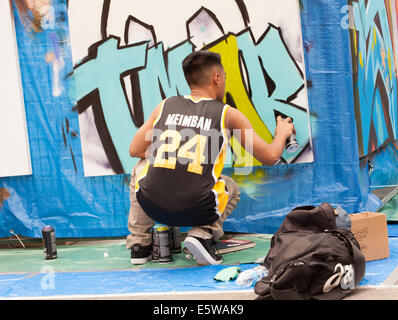 Man spraying graffiti :  The 6th Annual UNITY Festival at Yonge-Dundas Square on Saturday, July 26,2014. Toronto,Canada Stock Photo
