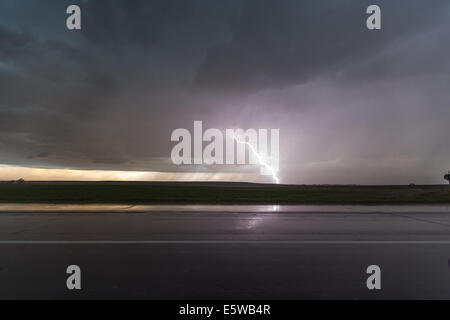 A lightning bolt shrouded in rain strikes the ground from a springtime time prairie thunderstorm in western Nebraska Stock Photo