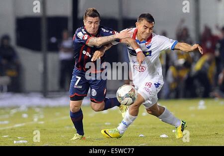 Asuncion, Paraguay. 6th Aug, 2014. Nacional's Derlis Orue (R) vies for the ball with Julio Buffanini (L) of San Lorenzo, during their first-leg final match of the 2014 Libertadores Cup, held at Defensores del Chaco Stadium, in Asuncion, Paraguay, on Aug. 6, 2014. Credit:  Jose Romero/TELAM/Xinhua/Alamy Live News Stock Photo