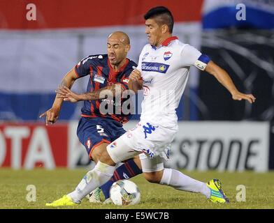 Asuncion, Paraguay. 6th Aug, 2014. Nacional's Jose Caceres (R) vies for the ball with Juan Mercier (L) of San Lorenzo, during their first-leg final match of the 2014 Libertadores Cup, held at Defensores del Chaco Stadium, in Asuncion, Paraguay, on Aug. 6, 2014. Credit:  Jose Romero/TELAM/Xinhua/Alamy Live News Stock Photo