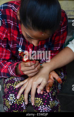 Painting Mehndi or Henna india style at Thamel market street Kathmandu Nepal Stock Photo