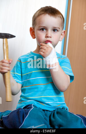 wounded in the left hand with bandage boy at shot in home Stock Photo