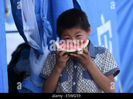 Ludian, China's Yunnan Province. 7th Aug, 2014. Zhang Xinggui, 12, eats