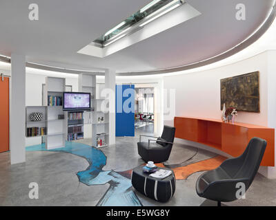 interior view of a modern living room overlooking on the entrance separated by a bookcase, the floor of resin decorated Stock Photo