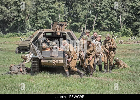 Squad of soviet soldiers capturing a german troop carrier during Reconstruction of a World War II fight. Stock Photo