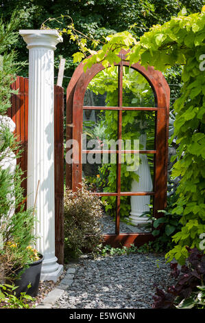 A mirror in a small courtyard garden creating the illusion of extra space Stock Photo