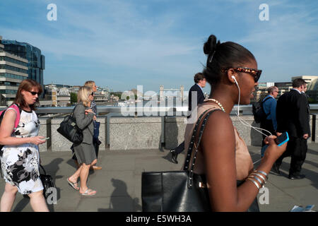 City of London woman female office workers commuters walk walking across London Bridge over River Thames after work in summer London UK   KATHY DEWITT Stock Photo