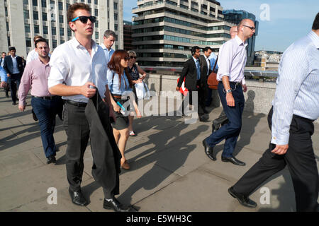 Office workers walking in crowd across London Bridge at rush hour after work on a hot day during a heatwave in the City of London UK KATHY DEWITT Stock Photo