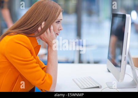 Female office worker staring at computer screen Stock Photo