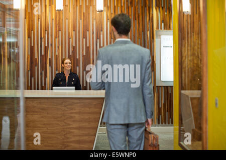 Businessman arriving at office reception Stock Photo