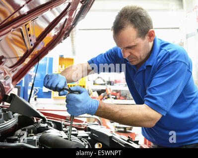 Mechanic working on car engine Stock Photo