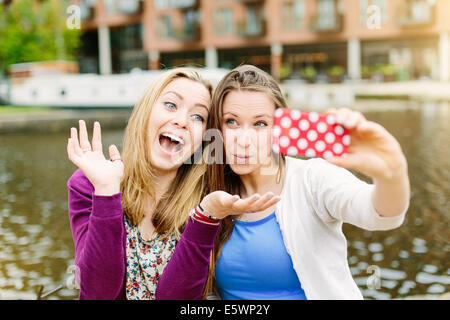 Friends taking selfie by canal Stock Photo