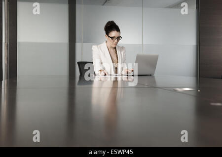 Young businesswoman using laptop in conference room Stock Photo