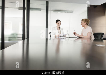 Two young businesswomen meeting in boardroom Stock Photo