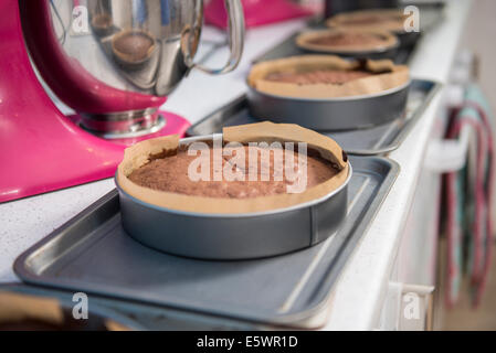 Row of cakes cooling off on top of ovens in bakery Stock Photo