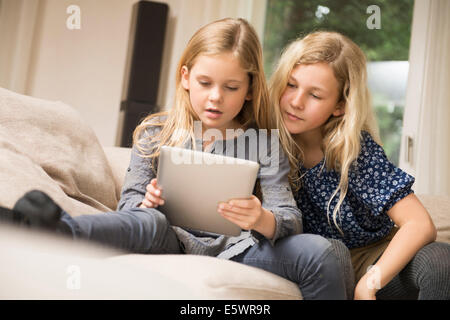 Two sisters using digital tablet Stock Photo