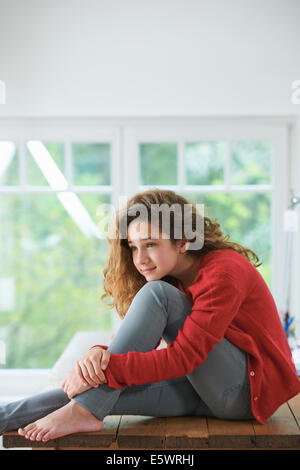 Young girl with brown hair, resting head on knee Stock Photo