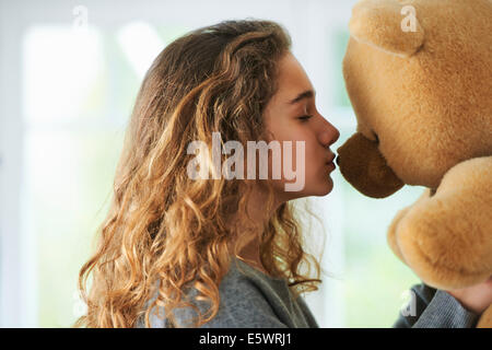 Portrait of young girl kissing teddy bear Stock Photo