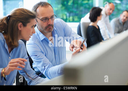 Colleagues looking at mobile phone Stock Photo