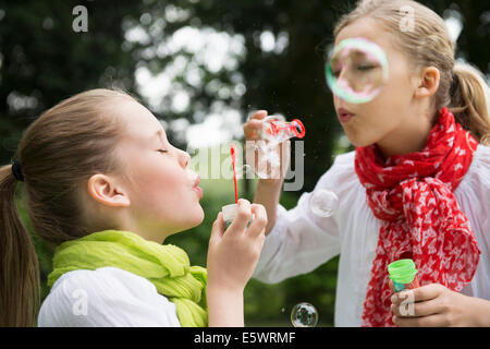 Two sisters blowing bubbles Stock Photo