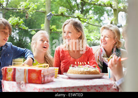 Girl making birthday wish with her family at birthday party Stock Photo