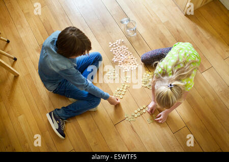 Brother and sister counting coins from savings jar Stock Photo