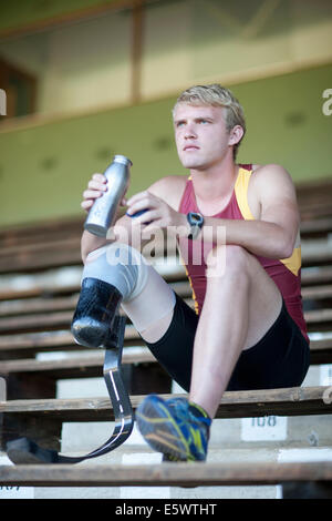 Sprinter sitting with prosthetic leg on Stock Photo